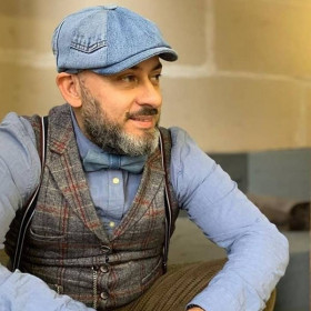 Mann mit Jeans-Fliege und Jeans-Schiebermütze.