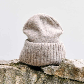Strickmütze aus ungefärbter beiger Schafschurwolle. Mit breit umgeschlagenem Rand.