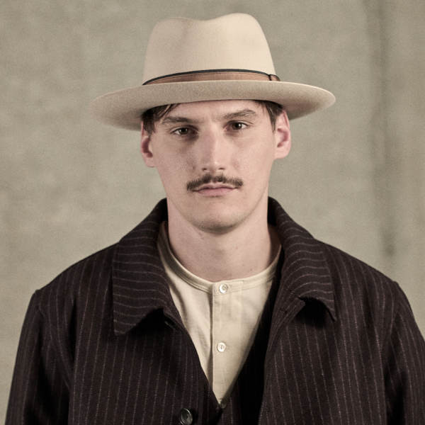 Männliches Model mit der Haarfilz Fedora "Brilliant" in der Farbe Elfenbein